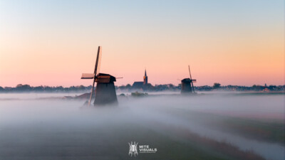 Aerial drone view of a classic Dutch windmill during sunrise with fog, Schermerhoorn, spring in Holland, The Netherlands